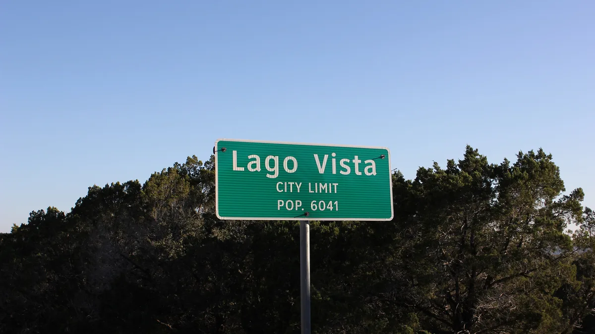 Lago Vista city limit sign against Texas Hill Country trees